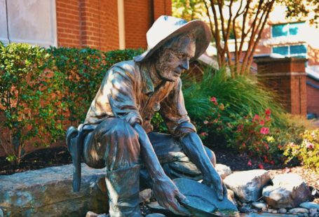 Shoe Styles Change - a statue of a man sitting on a rock