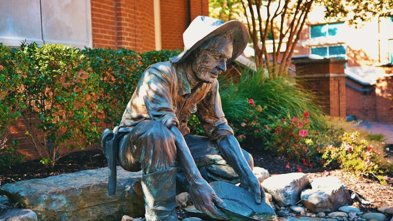 Shoe Styles Change - a statue of a man sitting on a rock