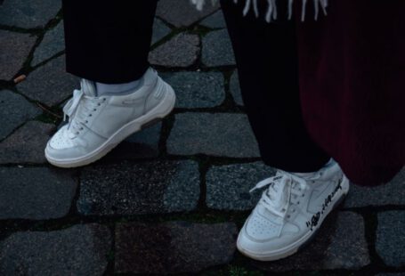 Customize Shoes - a person standing on a cobblestone walkway wearing white sneakers
