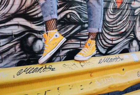 Shoes Affect Posture - person standing on yellow guard rail