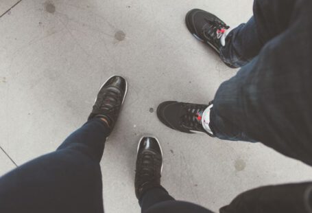 Metallic Shoes - person in blue denim jeans and black and white sneakers