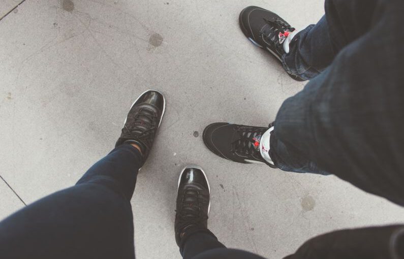 Metallic Shoes - person in blue denim jeans and black and white sneakers