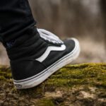 Organic Materials Footwear - person wearing black and white Vans Sk8-Hi