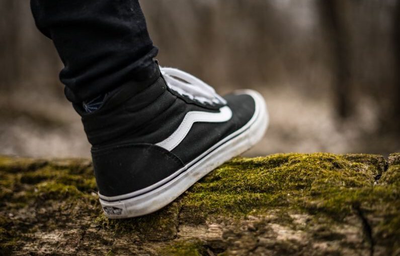 Organic Materials Footwear - person wearing black and white Vans Sk8-Hi