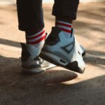 Retro Sneakers - a person wearing white and black shoes