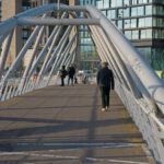 Foot Arch - a man walking across a bridge over a river