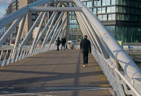 Foot Arch - a man walking across a bridge over a river