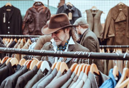 Online Shoes Shopping - man in brown cowboy hat in front of hanged suit jackets