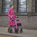 Transform Shoes - a woman in a pink dress pushing a pink walker