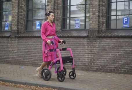 Transform Shoes - a woman in a pink dress pushing a pink walker