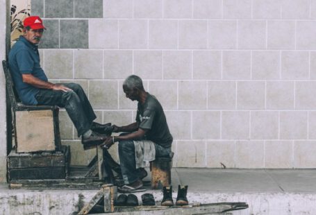 Shoe Polishing - man sitting on stool cleaning shoes at the alley