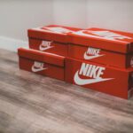 Personalized Sneakers - a pair of red nike boxes sitting on top of a wooden floor