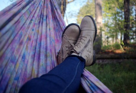 Shoe Dyeing - person lying on pink and purple hammock surrounded with trees