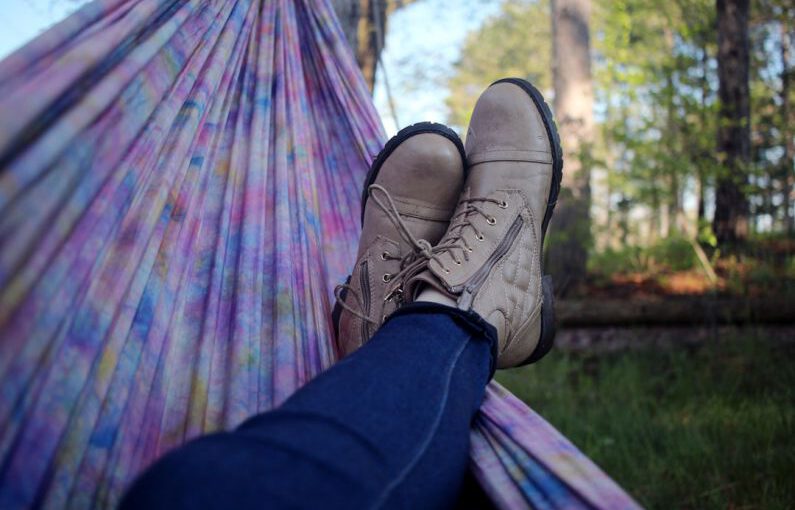 Shoe Dyeing - person lying on pink and purple hammock surrounded with trees