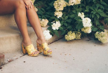 Shoe Embroidery - woman sitting on brown stair beside yellow and white flowers