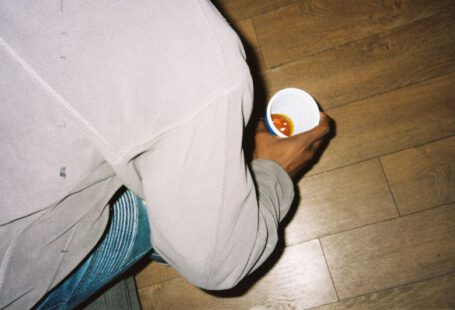 Iconic Shoes - person in gray pants holding white plastic cup