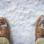 Shoes Battles - top view photography of person standing on snow covered field