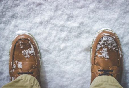 Shoes Battles - top view photography of person standing on snow covered field