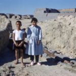 Archaeological Footwear - 2 women standing on gray sand during daytime